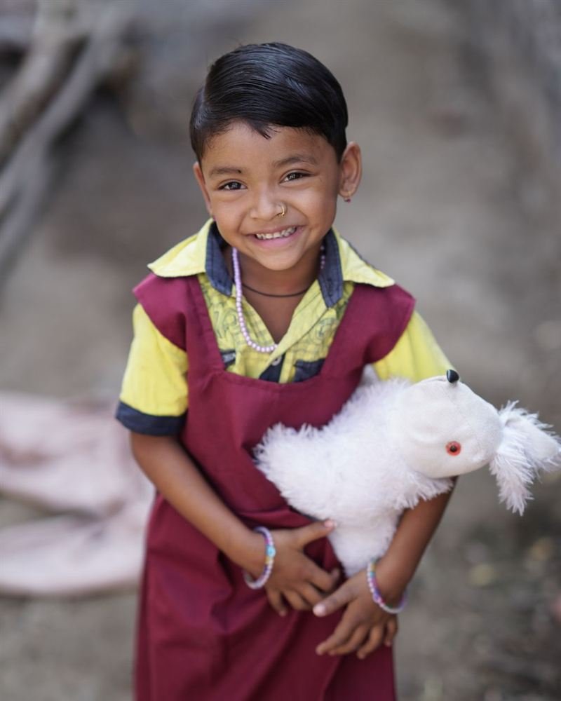 A smiling young girl in a school uniform