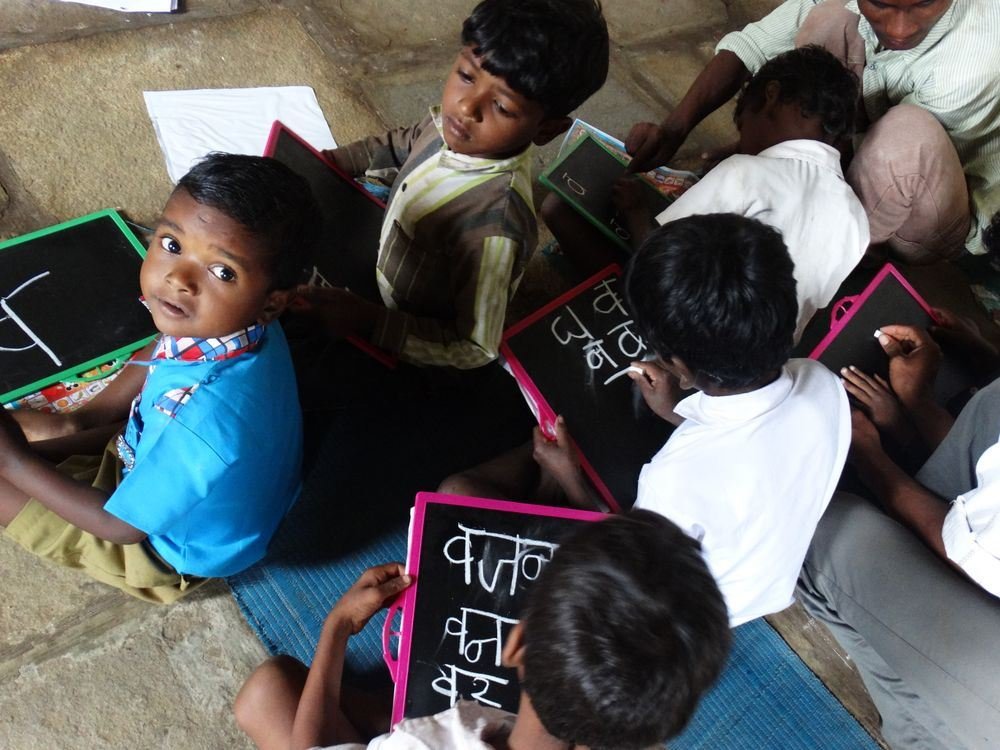 Children learning to write on slates in a village school